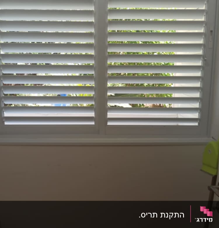 תריסי אלומיניום לבנים על חלון